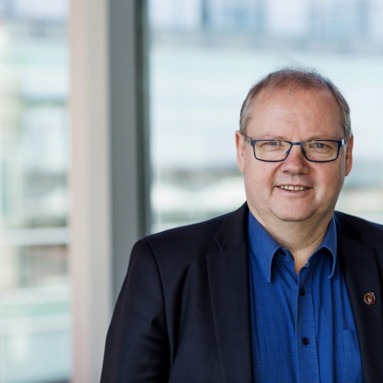 Jonny Gulbrandsen smilende med uklar bakgrunn. Portrett. Foto Jonny Gulbrandsen smilende med uklar bakgrunn. Portrett. Foto