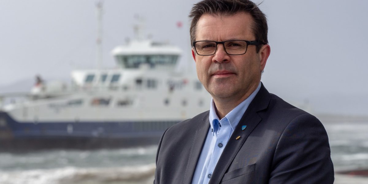 Foto av Frank Sve med ferge i bakgrunnen Foto av Frank Sve med ferge i bakgrunnen