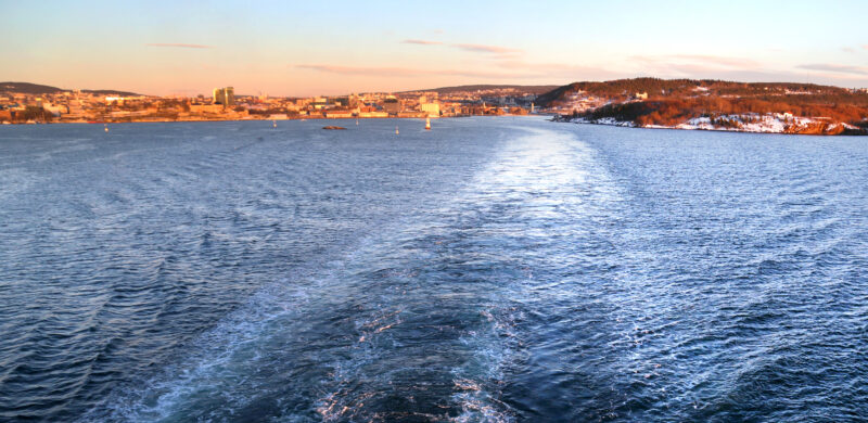 Blått hav. I bakgrunnen sees fjellandskap. Foto. Blått hav. I bakgrunnen sees fjellandskap. Foto.